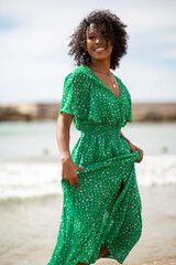 Wall Mural - smiling african american woman standing by beach