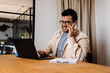 © Drobot Dean - Smiling business man talking on mobile phone while working in office