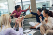 © Mediteraneo - A group of professional people sitting on the floor of the office and working together