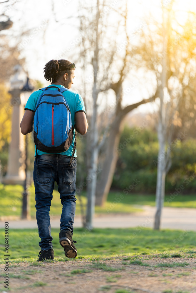 Young black student with a bag walking around the park Stock Photo ...