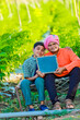 © SDV Ads - Cute indian farmer child in school uniform with his father at agriculture field