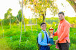 © SDV Ads - Cute indian farmer child in school uniform with his father at agriculture field
