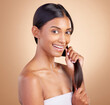 © Nadia L/peopleimages.com - Strong hair, portrait or happy girl with beauty, skincare or self care for glow, shine or collagen in shampoo. Healthy texture, model or Indian woman smiling with cosmetics for treatment or grooming