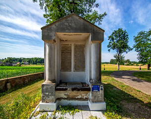 Wall Mural - General view and architectural details of the early 19th century brick chapel, wooden belfry and St. Roch Catholic Church in the village of Miłkowice Maćki in Podlasie, Poland.