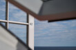 Geöffnete weiße Balkontür mit einer aufgeklebten Zahl 42 hinter einem geöffneten Dachfenster mit Blick auf das geöffnete Meer