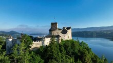 Poland. Medieval Castle In Niedzica, 14th Century (upper Castle), Polish Or Hungarian In The Past. Artificial Czorsztyn Lake. Aerial Revealing Video In The Morning In Sunrise Light