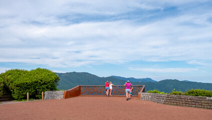 Wall Mural - Tourist couple looking at the view of Furnas Lake from the viewpoint of Pico do Ferro. Sao Miguel island in the Azores