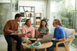 © DragonImages - Group of diverse teenagers gathered at home to discuss school project