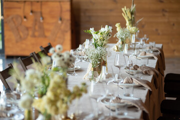 Wall Mural - beautiful table setting with flowers and cutlery on wooden table at wedding or dinner. stylish tablewear decorations