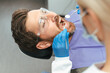 © Maria Vitkovska - Dentist examining patient in modern dental clinic. Teeth treatment, health care, oral hygiene concept