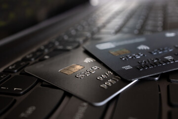 Credit cards over laptop keyboard closeup selective focus