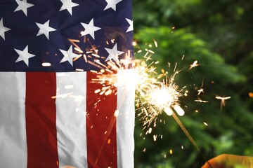 Wall Mural - Hand holding a sparkler and American Flag