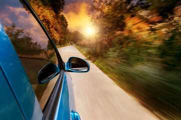 Canvas Print - Car driving fast into forest with blurred motion