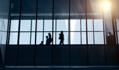 Wall Mural - Silhouettes of business people walking in morden building