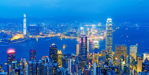 Hong Kong cityscape with victoria harbour and large group of tall buildings at night