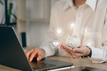 businessman holding piggy bank in glass with using computer and calculator to calculate concept saving money for finance accounting.