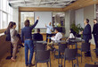 © Studio Romantic - Old man coach or trainer talking with his students colleagues businesspeople at office meeting. Employees or colleague discuss business project strategy or idea on team briefing. Teamwork concept.