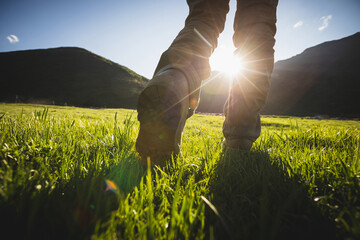 Wall Mural - Woman hiker walking on trail in grassland