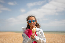 Portrait Of Smiling Girl (8-9) Eating Ice Cream On Beach
