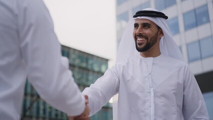 Wall Mural - Handsome businessman with the traditional emirates white outfit working outdoor in Dubai city. Concept about middle eastern cultures and business