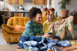 © ReeldealHD images - Friends taking photos of vintage second hand thrift clothes to sell online