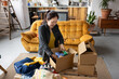 © ReeldealHD images - Female entrepreneur packing orders into cardboard boxes to ship