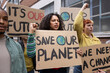 © ReeldealHD images - Young adult female protester raising her fist up at a climate change protest