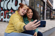 © ReeldealHD images - Two friends taking a selfie on a city break