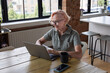 © ReeldealHD images - Happy senior female at home using a laptop for personal finances