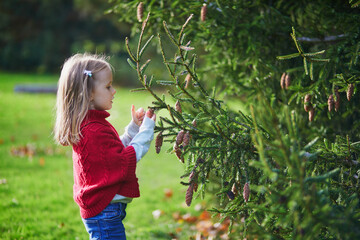 Wall Mural - Adorable preschooler girl in Parisian park on a spring or fall day