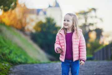 Wall Mural - Adorable preschooler girl enjoying nice autumn day in Saumur, Maine-et-Loire department, Western France