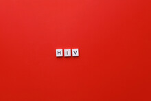 HIV Day. AIDS Day. Flatly Inscription Hiv From Wooden Letters On A Red Background