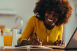 © Zamrznuti tonovi - A happy african american female manager is working from home remotely on the laptop while writing down tasks.