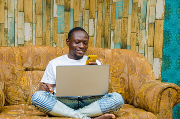 A man sitting on a couch using cell phone