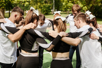 Wall Mural - Cheerleader team standing in circle and saying the words of support to each other before competition