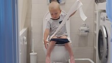 Baby Toddler Sitting On Toilet Learning Potty Training Child In Bathroom