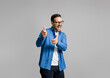 © Moon Safari - Portrait of handsome cheerful young businessman pointing at camera while posing on gray background