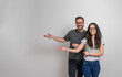 © Moon Safari - Portrait of cheerful young man and woman gesturing at copy space for advertisement. Smiling couple wearing eyeglasses presenting empty space for promotion against background