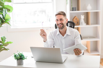 Mature business man using laptop computer in office.