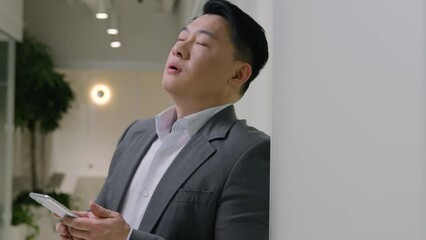 moving shot upset tired middle-aged asian man hold smartphone ethnic chinese japanese anxious korean