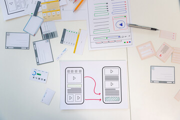 Top view of Creative flat lay UX designer working space and office supplies. Smartphone application layout prototype project.