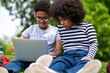 © zinkevych - Two kids sitting on the grass and spending time online