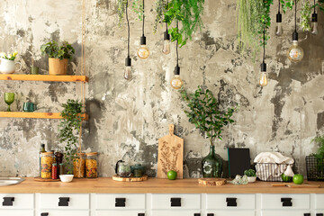 Wall Mural - Interior scandi open cuisine. Wooden shelves with various cookware, plants in pots and decoration in the kitchen. Loft pendant Edison light bulbs lamps on background of rough cement plaster on wall.	
