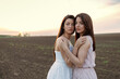 © pucko_ns - Two beautiful long hair woman hug in the middle of the agroculture field