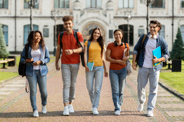 Wall Mural - Group of cheerful college students walking out of campus together