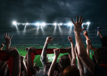 Football Scene At Night Match With With Cheering Fans At The Stadium