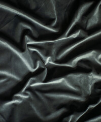 Black velvet with folds, luxury silk fabric background