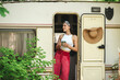 © teksomolika - Happy hippie girl are having a good time with cup of tea in camper trailer. Holiday, vacation, trip concept.