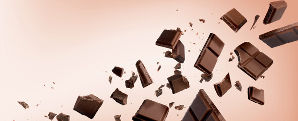 Wall Mural - Broken chocolate bar pieces falling on pink beige background. Banner design with space for text