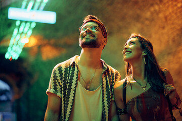 Happy couple at festivalgoers coming to summer music concert at night. Happy couple at festivalgoers coming to summer music concert at night.